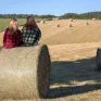 Deux jeunes femmes assises sur des meules de foin dans la campagne